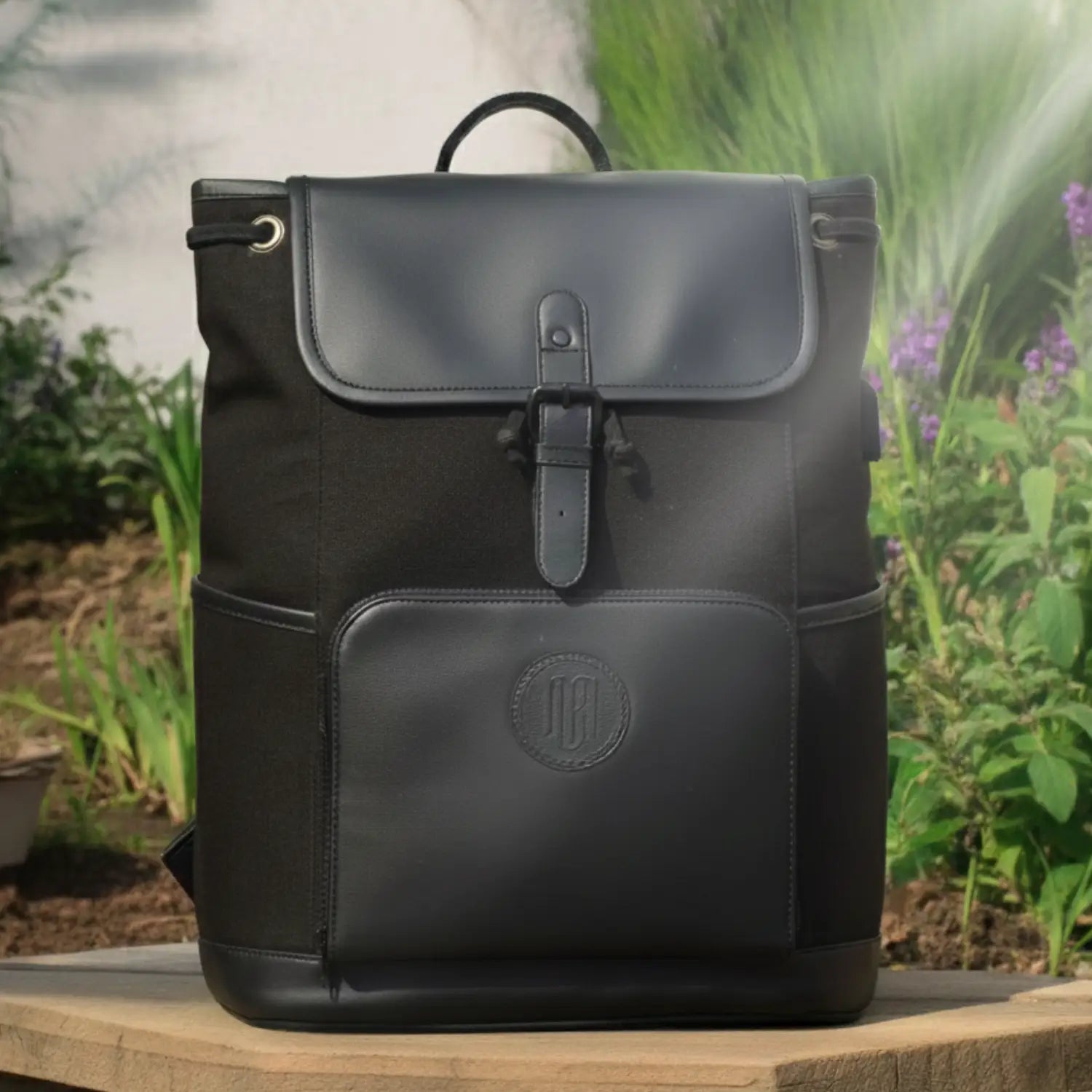 Black backpack with a visible brand logo on a wooden surface with a natural background