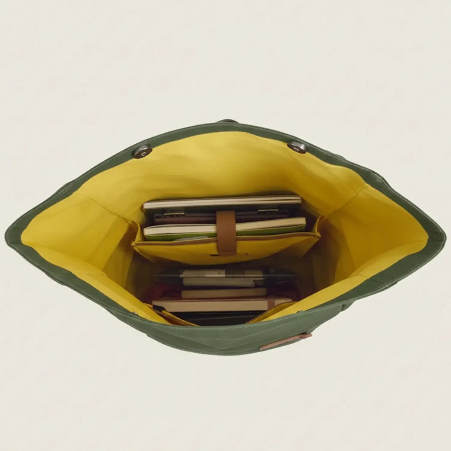 Green and yellow bag with books inside on a white background