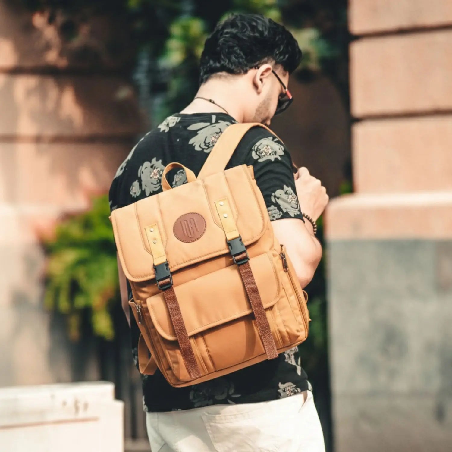 Person wearing a mustard backpack outdoors with a blurred background